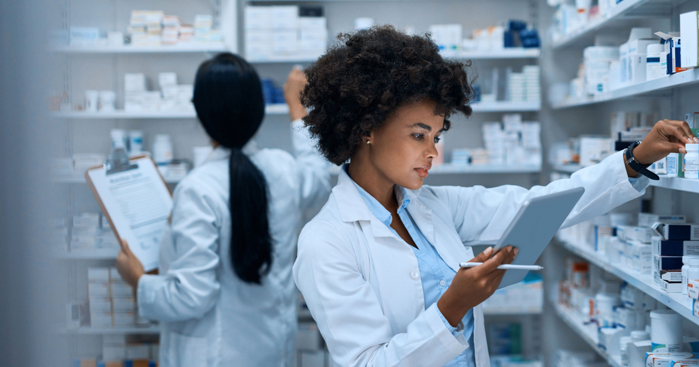 A photo of a pharmacist getting medication from a shelf for a patient.